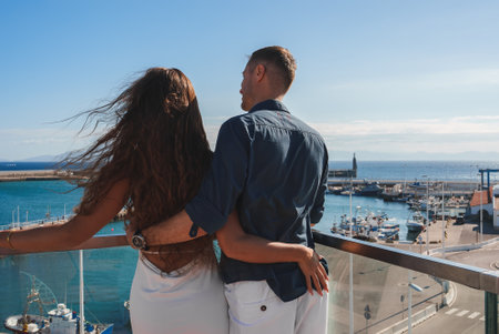 Couple on Balcony Overlooking Marina and Lighthouse in Tarifa, Spainの写真素材