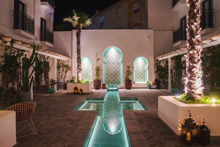Luxurious Moroccan Courtyard at Night with Reflective Poolの写真素材