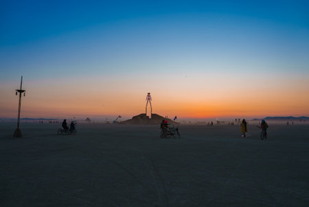 Desert Sunset with Art Installation and Bicyclists at Festivalの写真素材