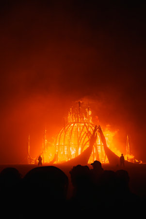 Large Wooden Art Installation Ablaze at Night in Desert Festivalの写真素材