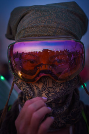 Festival Participant with Reflective Goggles in Desert Settingの写真素材