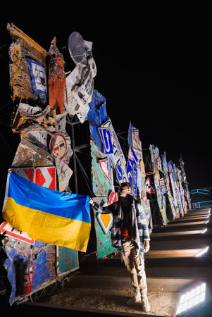 Nighttime Festival Scene with Road Sign Art Installation and Flagの写真素材