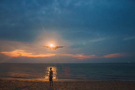 Sunset Beach Scene with Airplane Landing Near Phuket, Thailand