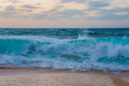 Turquoise Waves Crashing on Sandy Beach at Sunrise or Sunset