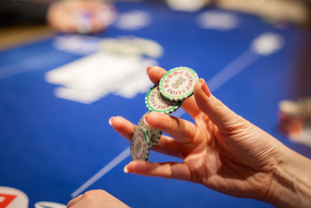 Close Up of Hand Holding Casino Poker Chips on Table