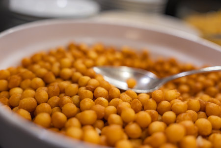 Close Up of Fried Golden Brown Snacks with Metal Spoonの写真素材