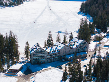 Aerial View of Frozen Braies Lake and Lodge in Winter Sunlightの写真素材