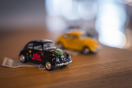 Miniature Vintage Cars with Floral Design on Wooden Surface Indoorsの写真素材