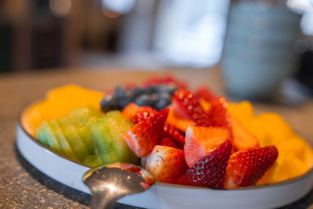 Close Up of Fresh Fruit Plate with Spoon on Textured Countertopの写真素材
