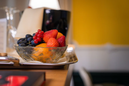 Glass Bowl of Fresh Fruits on Silver Tray in Cozy Interior Settingの写真素材