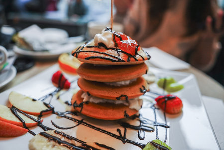 Golden Brown Pancakes with Whipped Cream and Fresh Fruit Garnishの写真素材