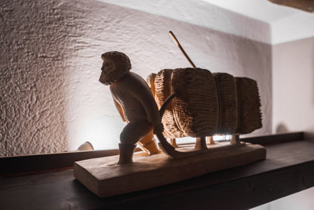 Wooden Sculpture of Bearded Man with Sled on Display in Italian Alpsの写真素材