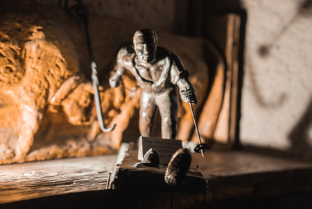 Metal Skier Sculpture on Wooden Surface with Carved Relief Background