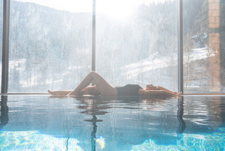Indoor Pool with Floor to Ceiling Windows Overlooking Snowy Alps