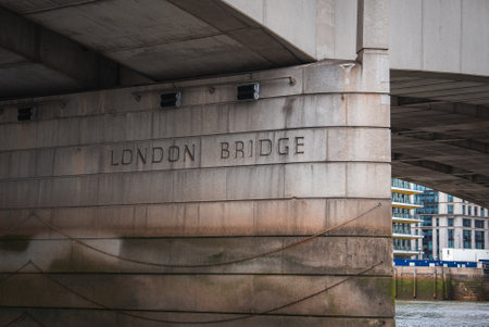 Close Up of London Bridge Base with Engraved Name and Urban Backgroundの写真素材