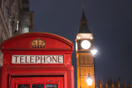 Red British Telephone Box with Big Ben Illuminated at Nightの写真素材