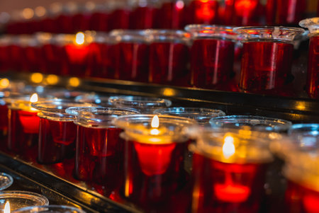 Rows of Red Votive Candles Lit and Unlit on a Black Metal Standの写真素材