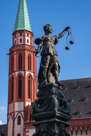 Fountain of Justice Statue and Old St. Nicholas Church in Frankfurtの写真素材
