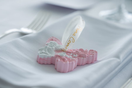 Close Up of Pink and White Cross Ornament on Formal Table Settingの写真素材