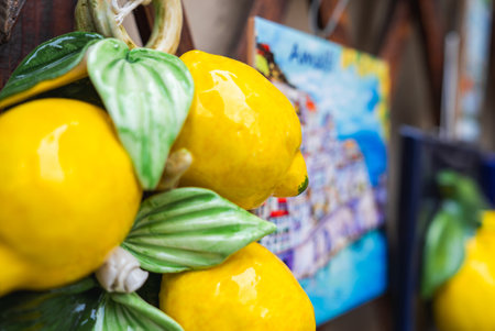 Close Up of Ceramic Lemons with Coastal Town Painting in Backgroundの写真素材