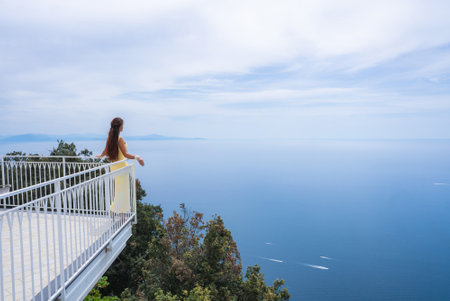 Woman in Yellow Dress on Balcony Overlooking Tyrrhenian Seaの写真素材