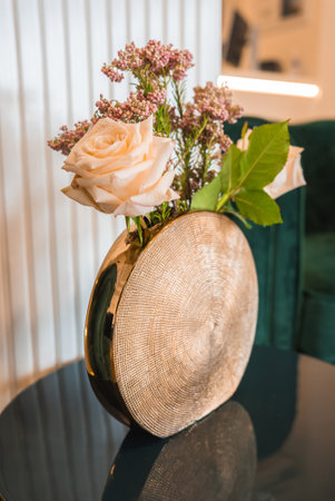 Decorative Gold Vase with Floral Arrangement on Black Surfaceの写真素材