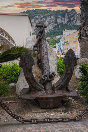 Rusted Anchor with Mediterranean Architecture at Sunsetの写真素材