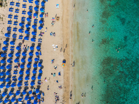Aerial View of Ayia Napa Beach with Blue Umbrellas and Turquoise Seaの写真素材
