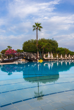 Luxury Resort Pool with Wooden Bridge and Palm Tree in Cyprusの写真素材