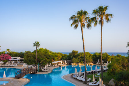 Luxurious Resort in Cyprus with Pool, Palm Trees, and Sea Viewの写真素材