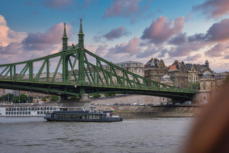 Liberty Bridge and Danube River with Boat in Budapest, Hungaryの写真素材