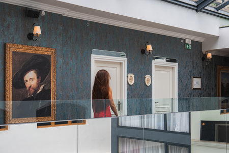 Interior of Luxury Boutique Hotel with Woman in Red Dress and Glass Ceilingの写真素材
