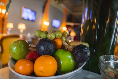 Bowl of Fresh Fruit on Marble Table in Luxurious Interior Settingの写真素材