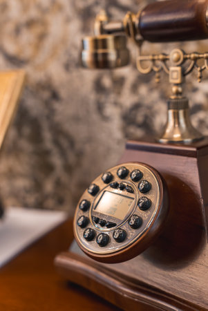 Vintage Rotary Telephone on Polished Wooden Surface in Rustic Settingの写真素材