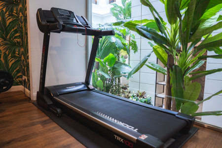 Modern Treadmill TRX100 in Luxury Gym Overlooking Tropical Gardenの写真素材