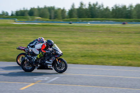 Two Sports Bikes Racing on a Track in a Rural Settingの写真素材