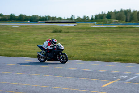 Motorcyclist Racing on a Black Sports Bike at Racing Trackの写真素材