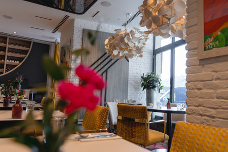 Modern Dining Area with White Chandelier and Yellow Chairsの写真素材