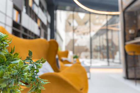 Modern Lounge Area with Mustard Yellow Armchairs and Glass Wallsの写真素材