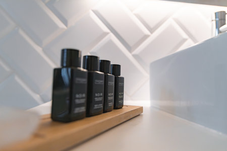 Modern Bathroom Countertop with Toiletry Bottles and Geometric Tilesの写真素材