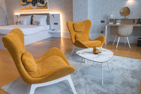Modern Hotel Room with Mustard Armchairs and Elegant Decorの写真素材