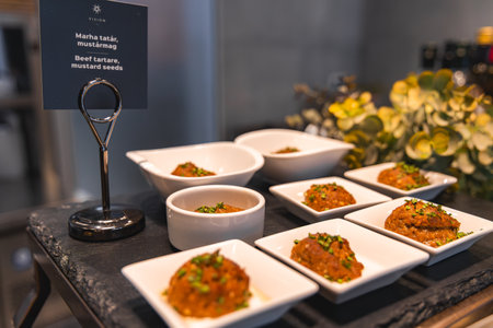 Beef Tartare Display in Luxury Hotel Dining Area with Floral Decorの写真素材