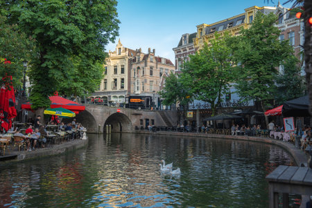 Canal with Stone Bridge and Outdoor Cafes in Utrecht, Netherlandsの写真素材
