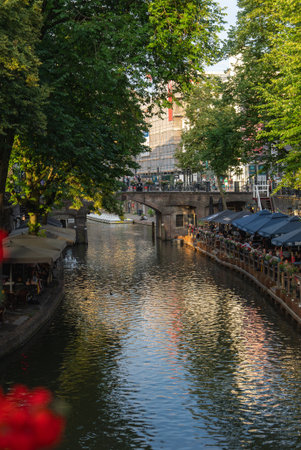 Canal in Utrecht, Netherlands with Stone Bridge and Outdoor Cafesの写真素材