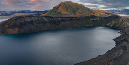 Volcanic Crater Lake with Colorful Mountain at Sunrise or Sunsetの写真素材