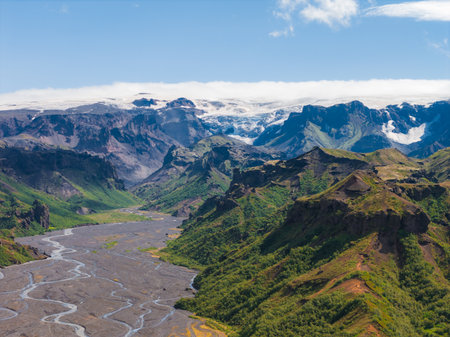 Aerial View of Lush Green Valley with Braided River and Glacier in Icelandの写真素材