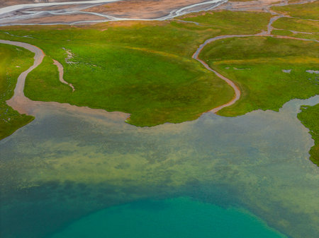 Aerial View of Lush Green Landscape and Turquoise Water in Iceland