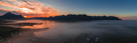 Aerial View of Icelandic Landscape with Mountains and Settlement at Sunset