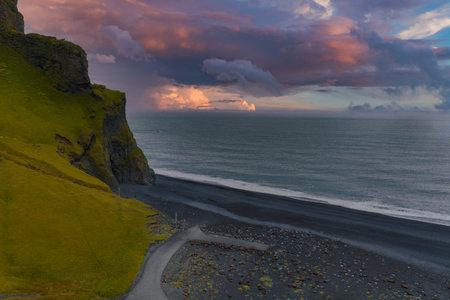 Aerial View of Icelands Black Sand Beach at Sunset with Mossy Cliff