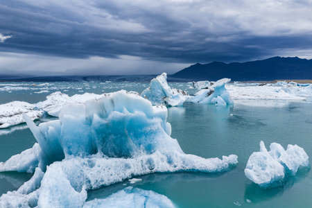 Jagged Icebergs in Jokulsarlon Glacier Lagoon with Mountain Backdrop